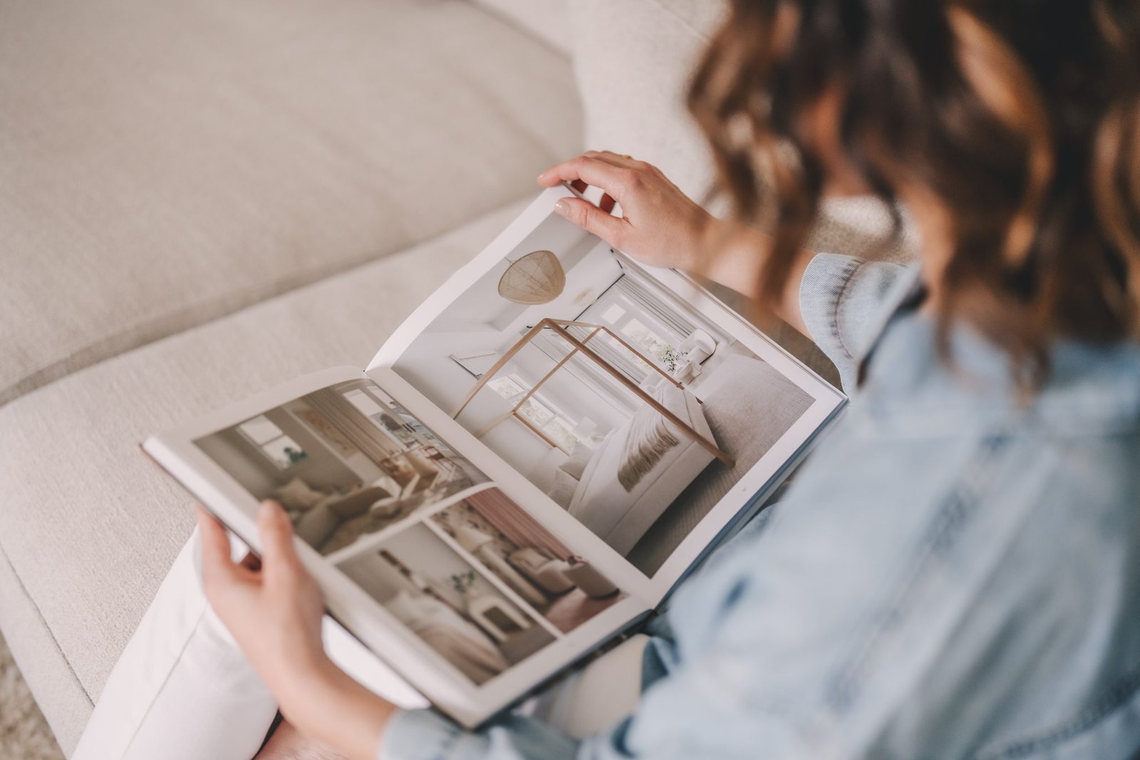 Viktoria Semmler INTERIORS blättert in einem Buch über Slow Living Interior Design auf einem Sofa